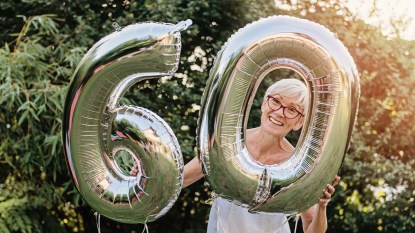 Mature woman celebrating her 60th birthday, with balloons