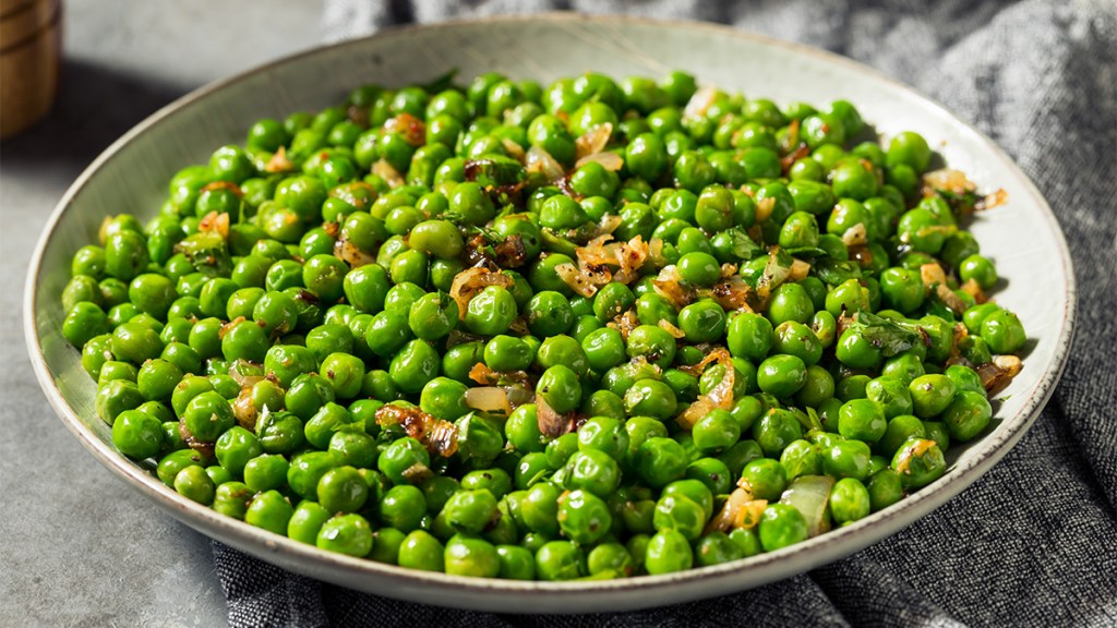 Sautéed peas with fried onions as part of a guide on how to cook the frozen veggie