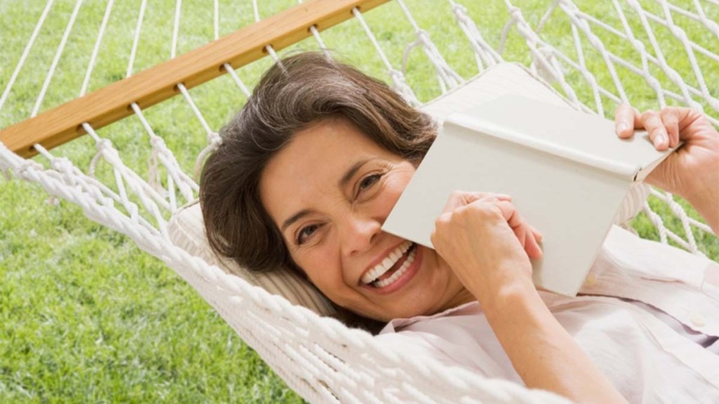 Woman reading a book while sitting in a hammock