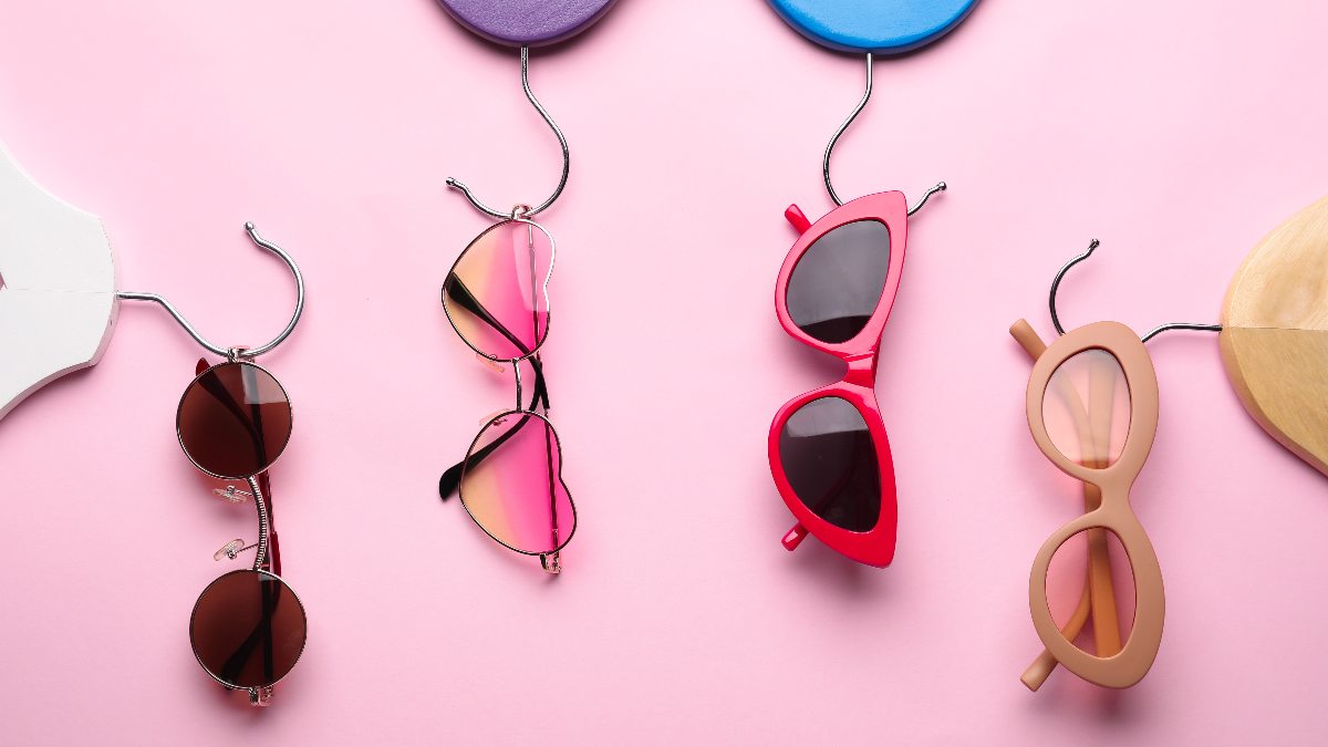 four pairs of colorful sunglasses on hangers