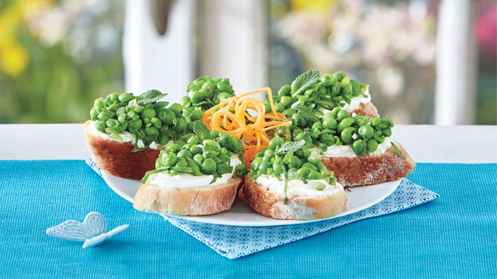 Plate of crostini topped with goat cheese and minty peas