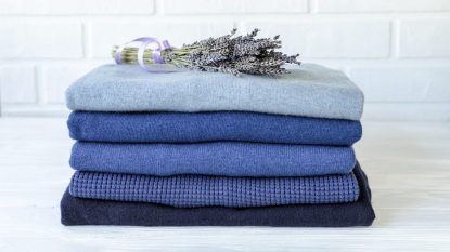 pile of knitted sweaters with sprigs of lavender on top