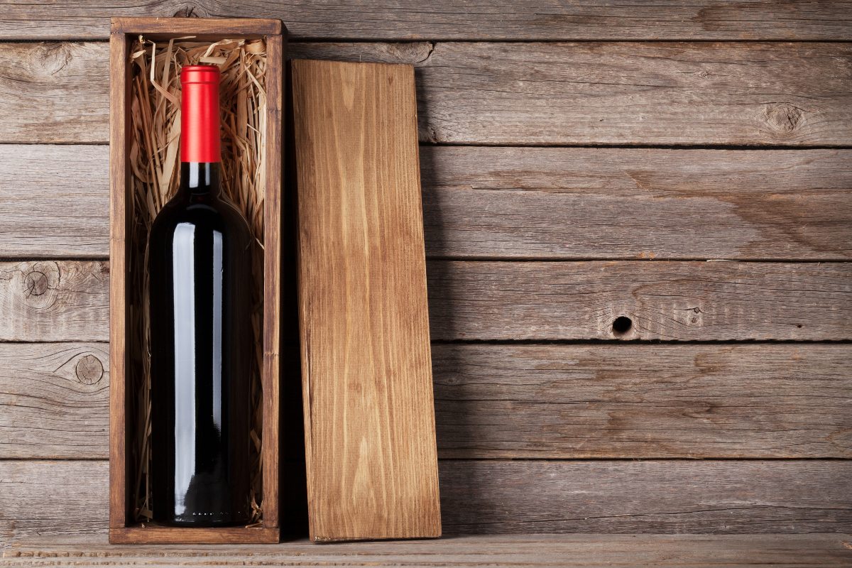 red wine in a wooden wine box on a wooden table