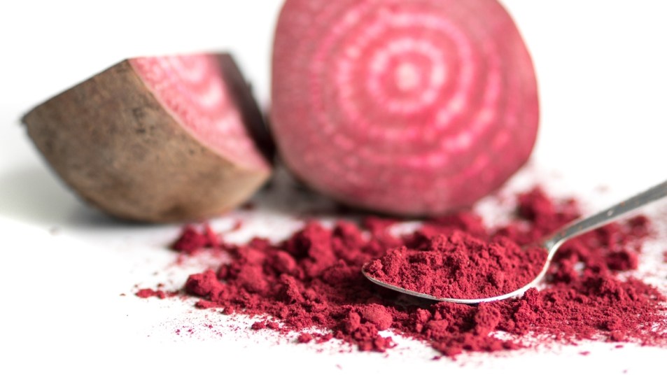 Beetroot Powder in front of Beetroot Fruit on isolated white background
