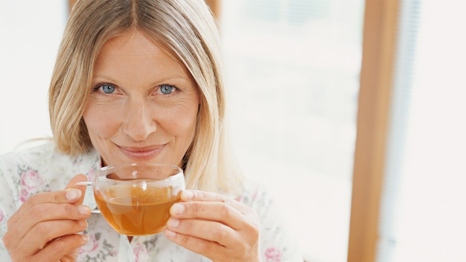 woman sipping tea: how to prevent a cold when you feel it coming