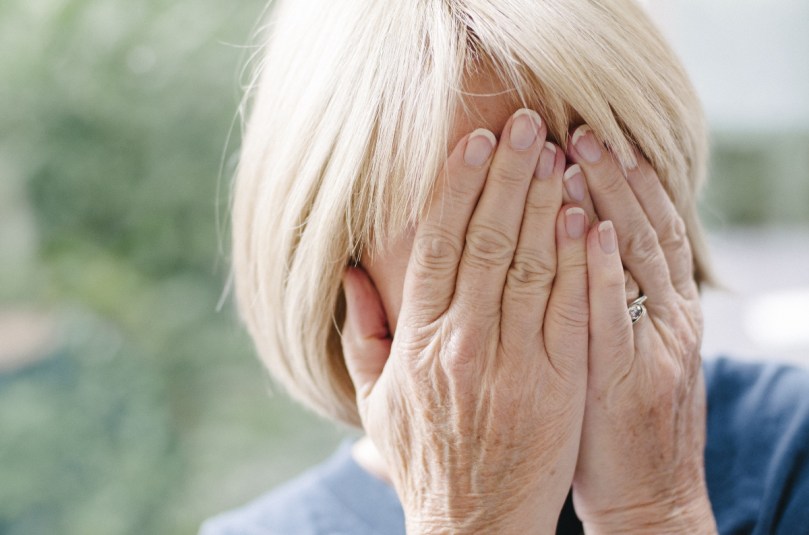 Mature woman covering her face in embarrassment