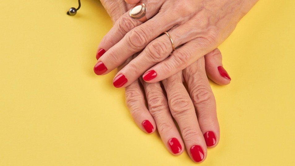 mature woman wearing red shellac nail polish