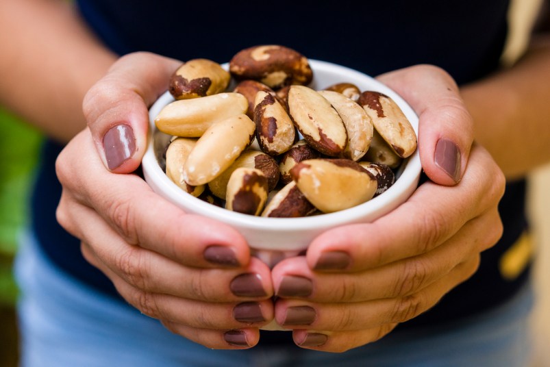 Woman holding bowl of Brazil nuts