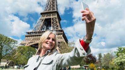 woman taking a selfie in front of the eiffel tower