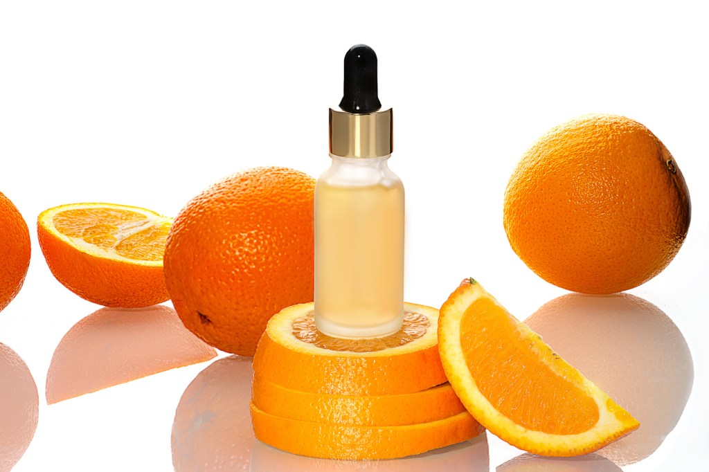Bottle of vitamin C serum on top of oranges