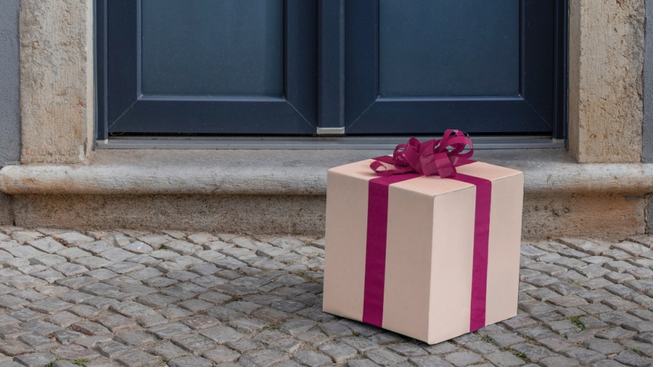 pink present in front of a blue door, concept for housewarming gifts