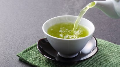 pouring green tea into a mug, concept for pre-diabetes