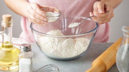 Woman using baking powder in kitchen