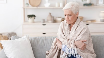 Woman wrapped in blanket on couch