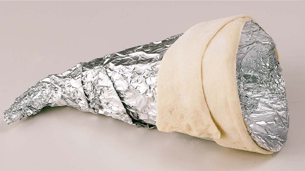 Step 2 of Thanksgiving cornucopia: wrapping dough around foil cone