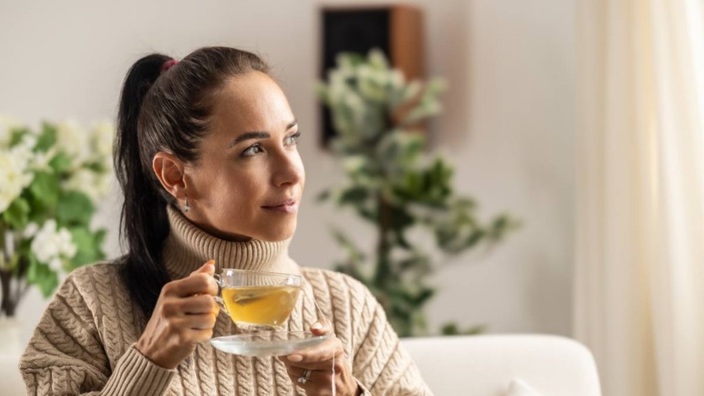 Woman in a sweater drinking tea