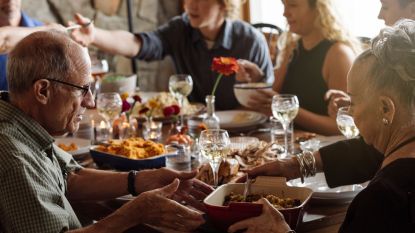 family sitting around thanksgiving dinner table