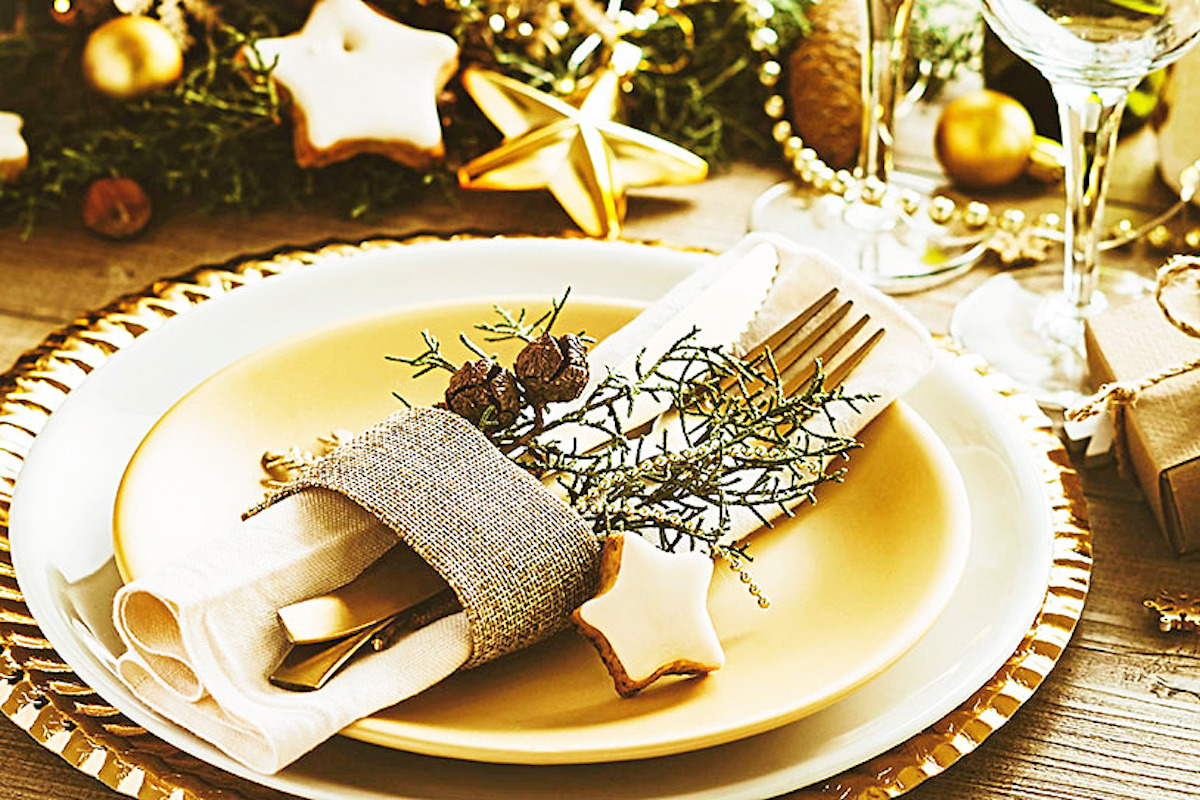 Gold place setting with evergreen sprigs and star-shaped cookie