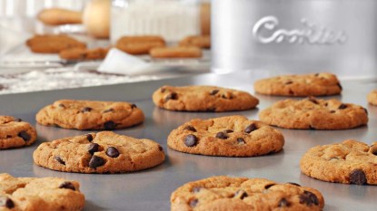 Freshly baked chocolate chip cookies on non-stick cookie sheet