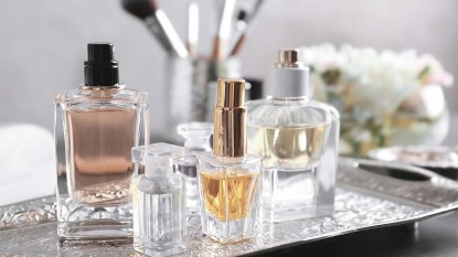 Metal tray with bottles of perfume on a table