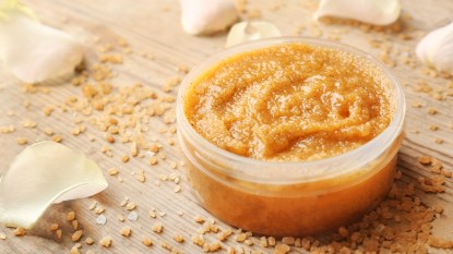 brown sugar scrub for the body surrounded by white petals