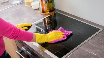 hand cleaning an electric stove top made of glass