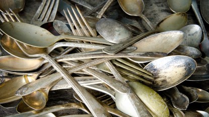 A pile of tarnished antique silver cutlery