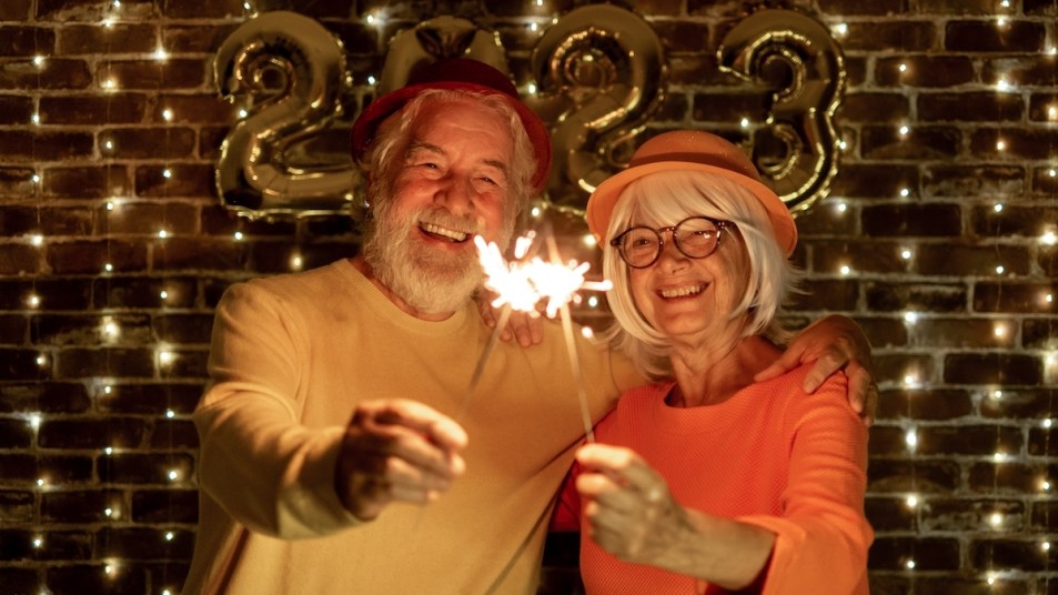 Couple with sparklers and 2023 New Year's Eve party balloons