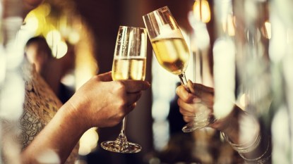 Two women's hands toasting champagne glasses