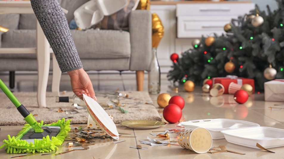 woman cleaning up christmas decorations on floor