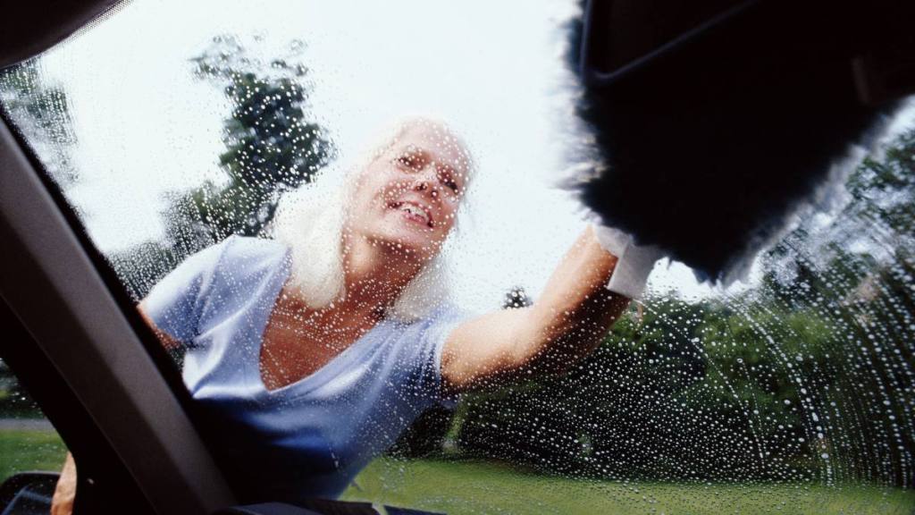 Woman washing a car window