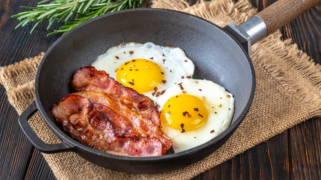 Eggs in a skillet with bacon