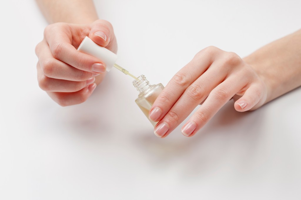 painting nails with clear coat and nail strengthener after removing dip nails