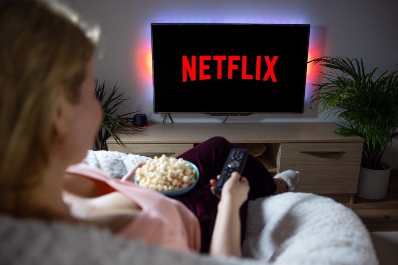 Woman watching TV at home with Netflix logo on the screen