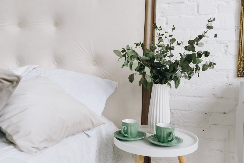 Two,Green,Cups,With,Saucers,And,Eucalyptus,Bouquet,On,Bedside