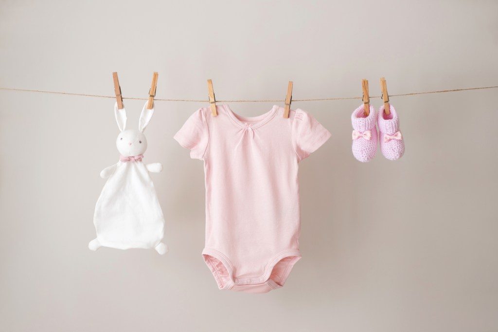 pink and white baby clothes hanging on a rope