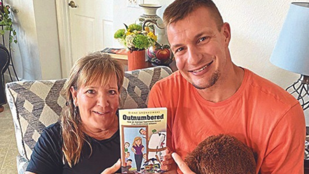 Diane and her son, Rob Gronkowski, holding her new book, Outnumbered