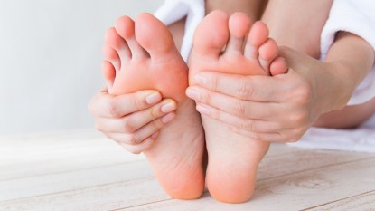 Close-up of woman's hands touching her feet