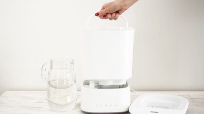 Woman's hand taking apart humidifier for cleaning