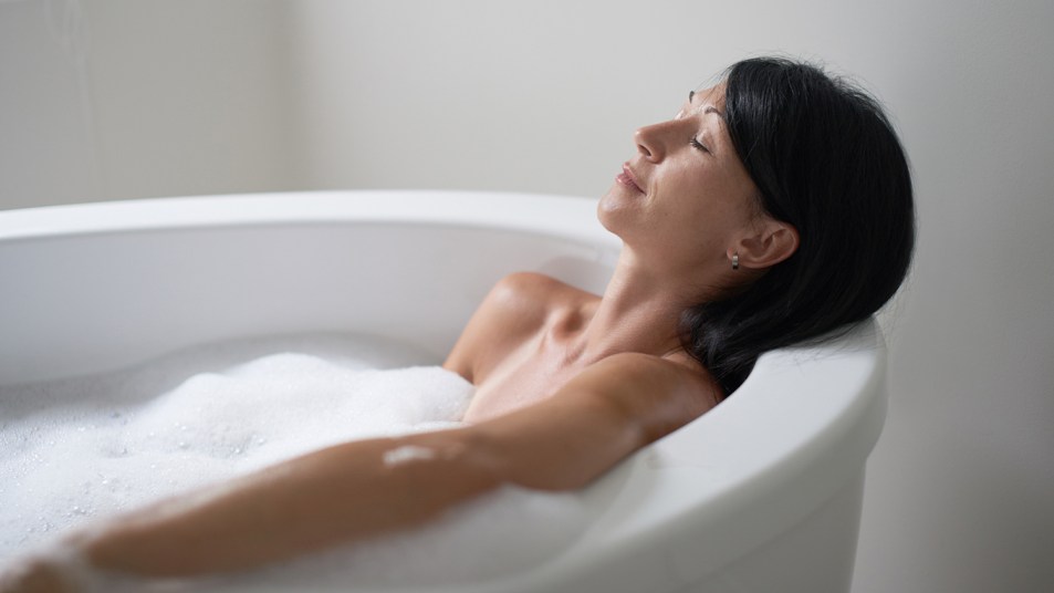 Relaxed lady in her forties relaxing in a modern soaking tub