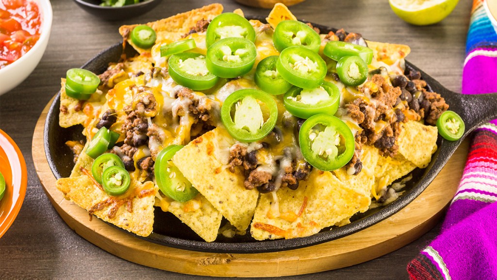 Nachos topped with ground meat as part of a guide on nacho variations