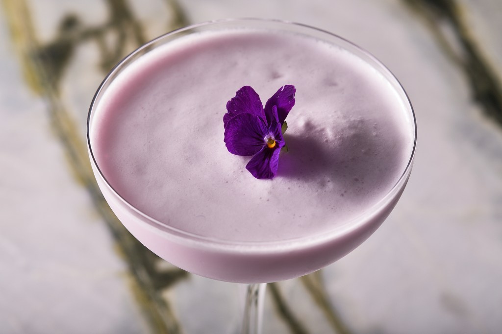 purple water, creamy purple cocktail up close with edible purple flower