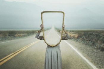 woman holding a mirror over her face