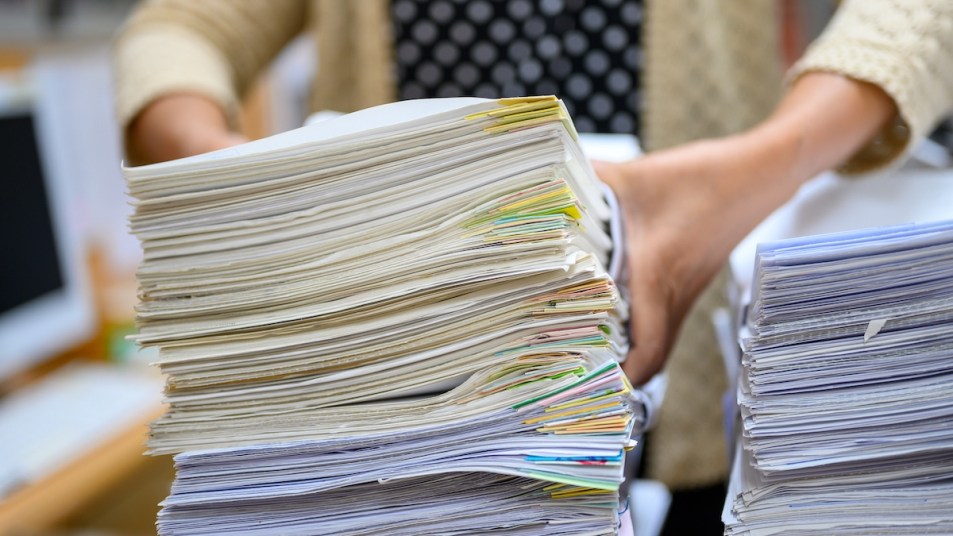Woman's hands holding stack of papers