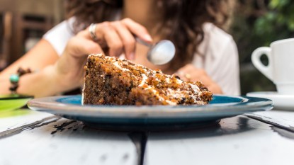 Woman's hands with plate of carrot cake
