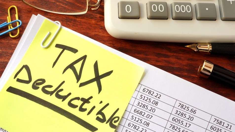 Tax papers with "Tax Deductible" post-it note and calculator
