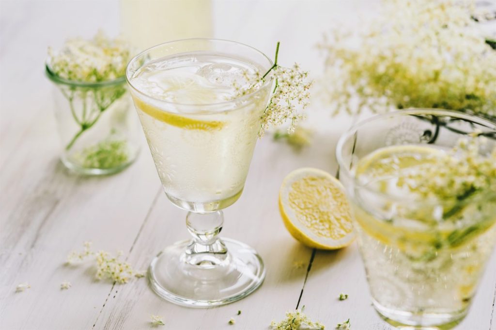 cocktail with lemon and elderflowers in small glass