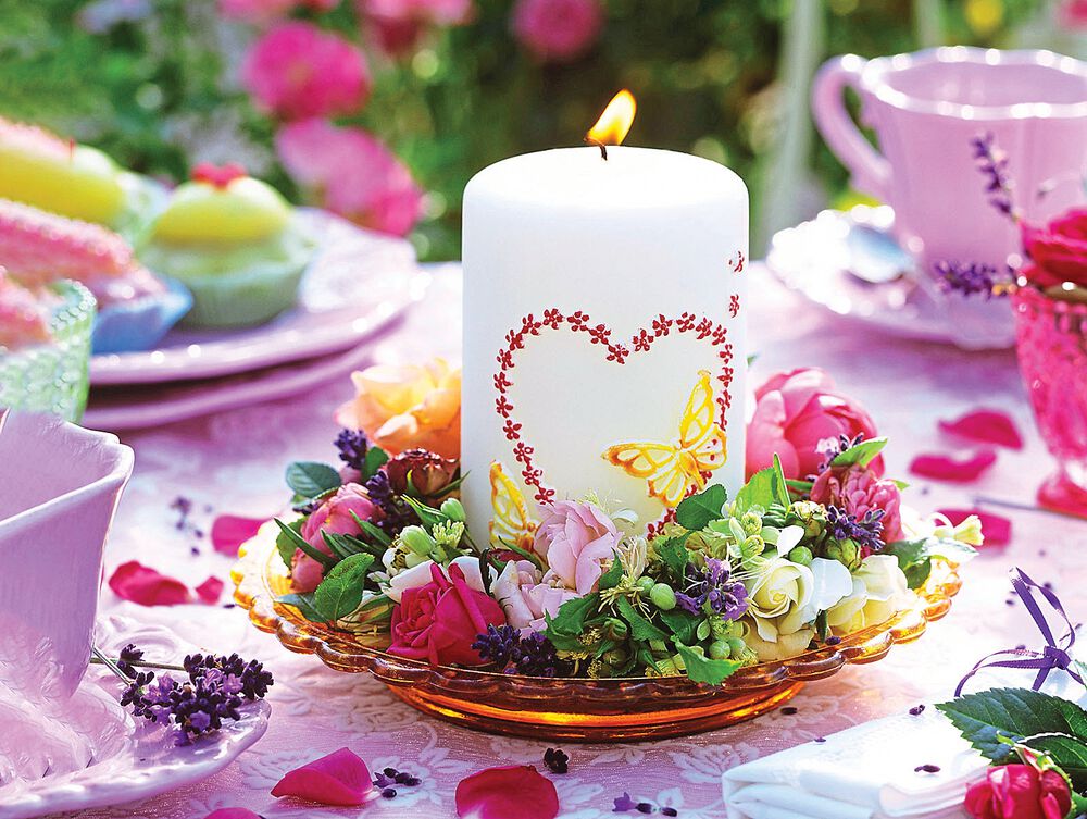 Flower wreath around candle with heart motif on plate
