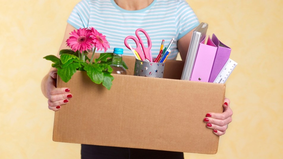 mature woman holding a box of arts and crafts materials, downsizing concept