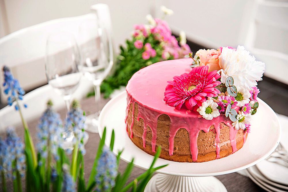 Spring dessert, naked cake with color icing, flower and red fruits inside